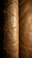 Close-up macro view of natural brown leather texture showing detailed grain patterns and surface creases for luxury craftsmanship and material design projects.