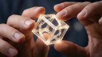 Hands holding glowing geometric wireframe cube with golden light, representing innovation, technology, and digital transformation for business concepts.