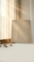 Minimalist beige canvas frame mockup with warm sunlight shadows on white surface near window with curtains for branding and artwork display.