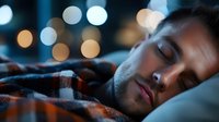 Young man sleeping peacefully in bed with soft bokeh city lights in background creating calm nighttime atmosphere for rest and relaxation concepts.