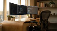 Modern home office workspace with dual monitor setup displaying programming code on wooden desk with ergonomic chair and natural lighting for productivity.