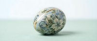 Hand-painted Easter egg with delicate blue floral pattern on white background, traditional folk art decoration for spring holiday celebrations.