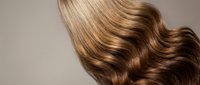 Luxurious flowing blonde and brown hair with silky smooth texture and natural highlights showcasing healthy hair care and beauty salon treatments.