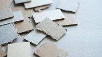Scattered cardboard puzzle pieces on white surface creating abstract pattern for creative projects and problem-solving concepts.