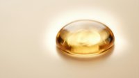 Golden gel capsule with glossy finish isolated on beige background, suitable for pharmaceutical, supplement, and wellness product packaging design.