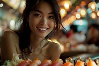 Young Asian woman smiling at sushi restaurant with bokeh lights in background, candid portrait capturing genuine happiness during dining experience.