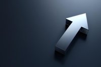 Metallic silver arrow pointing upward on dark background symbolizing growth, success, and positive direction for business presentations and financial concepts.