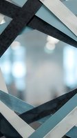Layered fabric ribbons in charcoal, white, and teal tones arranged in geometric pattern over soft-focus bokeh background, suitable for design, branding, and creative projects.