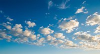 Bright blue sky with fluffy white cumulus clouds scattered across the horizon, evoking freedom and tranquility for backgrounds and weather concepts.
