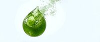 Fresh green lime splashing into clear water creating dynamic bubbles and droplets against clean white background for beverage advertising.