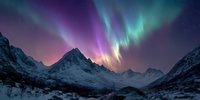 Spectacular aurora borealis dancing over snow-covered mountain peaks in arctic landscape with vibrant green and purple northern lights illuminating winter sky.