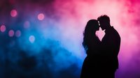 Romantic silhouette of couple against vibrant pink and blue bokeh background, intimate moment with foreheads touching, dreamy atmospheric lighting creates mood.