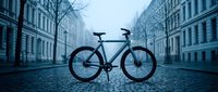 Modern bicycle parked on empty cobblestone street lined with historic buildings, urban commuting and sustainable transportation concept for city lifestyle designs.