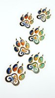 Decorative paw print brooches featuring colorful gemstones and enamel details in blue, orange, and green tones. Isolated jewelry design elements suitable for fashion illustration, clipart, and textile applications.