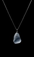 Elegant silver chain necklace with natural stone pendant on black background for jewelry design and fashion accessories.