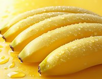 Fresh ripe yellow bananas with water drops on smooth peel surface against yellow background, macro food photography with selective focus.
