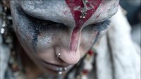 Young woman with dramatic fantasy makeup featuring silver and red face paint in tribal warrior style for cosplay and creative projects.