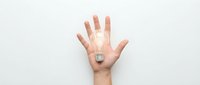 Open hand with glowing light bulb in palm representing creativity, innovation and bright ideas on white background for business concepts.