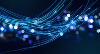 Abstract blue light trails with glowing particles and bokeh effects on dark background for technology and digital design projects.