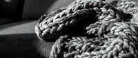 Chunky knit sweater with braided cable pattern detail in monochrome, showcasing cozy knitwear texture for fashion and lifestyle content.