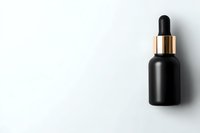 Black matte cosmetic dropper bottle with gold cap on white background, minimal composition for luxury skincare and beauty product packaging design.