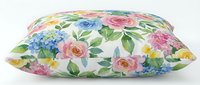 Decorative pillow with vibrant floral pattern featuring pink roses, blue hydrangeas, and yellow flowers on cream background, isolated on white for home decor design use.