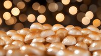 Glowing golden mushrooms on dark background with bokeh lights create magical forest atmosphere. Macro photography reveals delicate textures and patterns.