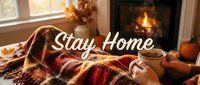 Cozy autumn stay home scene with hands holding a warm mug under a plaid blanket by a fireplace, fall decor in background.