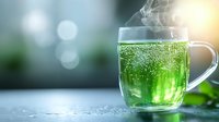 Steaming hot green tea in transparent glass cup with bokeh background and morning sunlight. Fresh mint leaves and rising vapor create serene atmosphere.