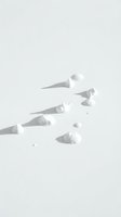 Monochromatic flat lay arrangement of white ice cream cones and scoops casting dramatic shadows on neutral background, suitable for minimalist design and advertising projects.