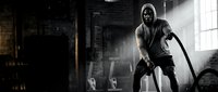 Hooded figure with sword in dark atmospheric warehouse setting with dramatic lighting and smoke effects for gaming and fantasy projects.