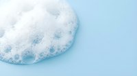 Soap bubbles and foam on light blue background, isolated for cleaning product advertising, laundry detergent packaging, and hygiene marketing materials.
