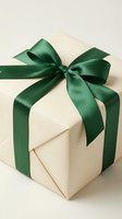 Elegant cream gift box tied with a dark green satin ribbon bow on a light background, perfect for holiday and celebration concepts.