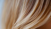 Close-up of flowing blonde hair with golden highlights showing smooth texture and natural movement for beauty and haircare concepts.