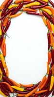 Colorful hot chili peppers arranged in a frame border with red, orange, and yellow varieties on white background, suitable for food and cooking content.