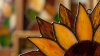 Decorative metal sunflower sculpture with golden yellow petals and dark center creates warm autumn ambiance for home decor and seasonal displays.