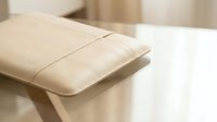 Elegant beige leather laptop sleeve case on wooden desk in modern minimalist office workspace interior design for professional business technology accessories.
