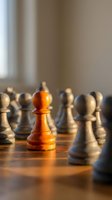 Orange wooden chess pawn standing out among white and black pieces on board, symbolizing leadership, strategy, and standing out from crowd in business.