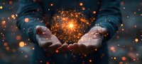 Magical glowing orange light particles floating above cupped hands against dark background, creating mystical atmospheric effect with bokeh and sparkles.