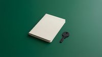 Blank notebook with vintage key on teal background, isolated for design mockups, branding, stationery concepts, and creative projects.