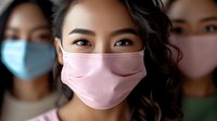 Young Asian woman wearing pink protective face mask with others in background wearing blue masks during pandemic health measures.