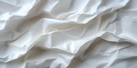 Crumpled white fabric with soft folds and wrinkles creating abstract texture and shadows, suitable for backgrounds, design overlays, and textile concepts.