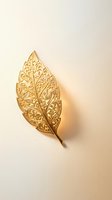 Golden ornate leaf with intricate filigree pattern and decorative swirls on neutral background for luxury design projects.