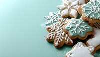 Festive snowflake gingerbread cookies decorated with white and turquoise royal icing on mint green background. Winter holiday baking with copy space.
