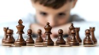 Wooden chess pieces on board with blurred young player in background focusing on strategy and next move, dramatic lighting creates competitive atmosphere.