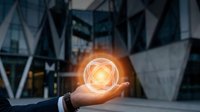 Businessman holding glowing geometric sphere with interconnected network patterns in modern corporate office environment for technology and innovation concepts.