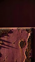 Aerial view of salt evaporation ponds with geometric patterns and vibrant pink and rust tones, casting long shadows across mineral-rich water for environmental and industrial concepts.