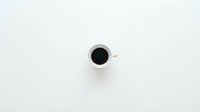 Black coffee in white ceramic cup viewed from above on clean white background for minimalist cafe branding and morning routine concepts.