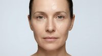 Middle-aged Caucasian woman with natural makeup-free skin showing authentic beauty and confidence against clean white background for skincare campaigns.