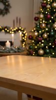 Wooden table surface with blurred Christmas tree and fireplace in background, warm holiday lights creating cozy festive atmosphere for product display.